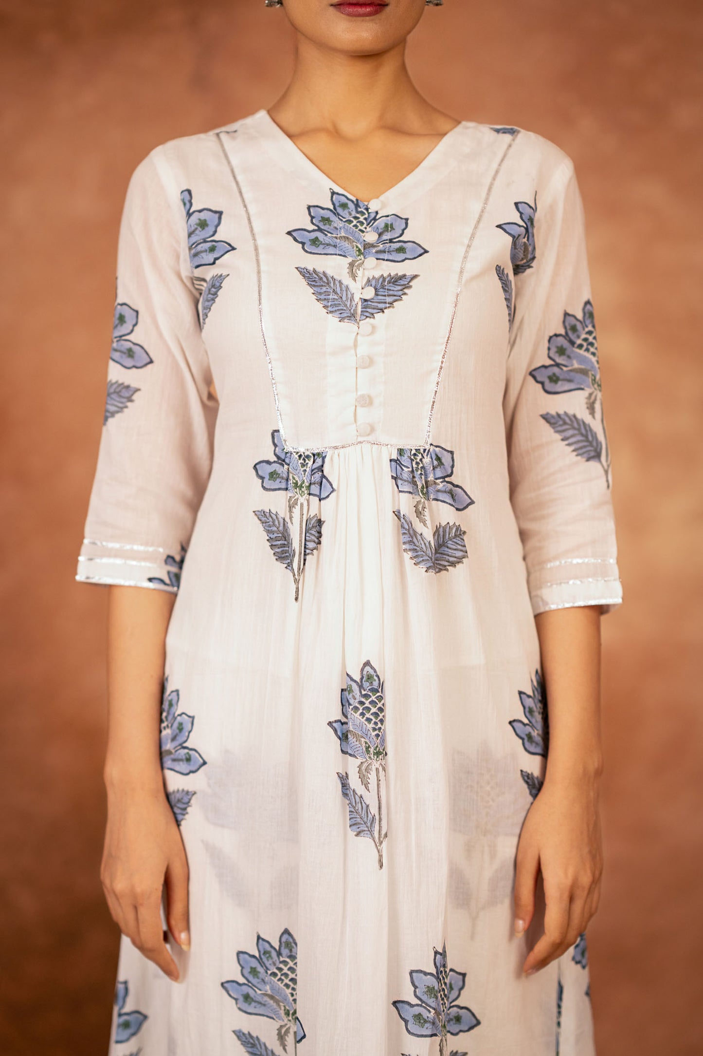 close up of blue floral hand block print on off white cotton fabric